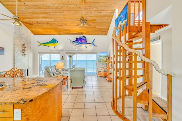 kitchen with light tile patterned floors, ceiling fan, high vaulted ceiling, a water view, and wooden ceiling