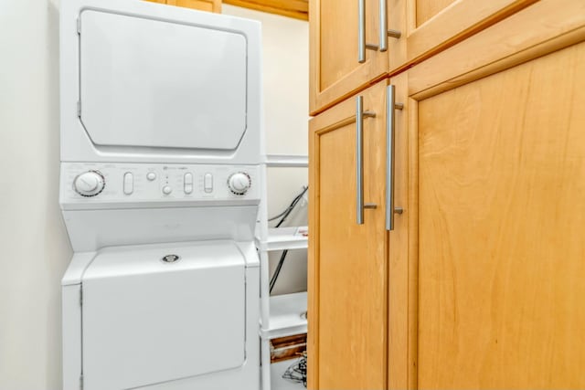 laundry room featuring cabinets and stacked washer and dryer