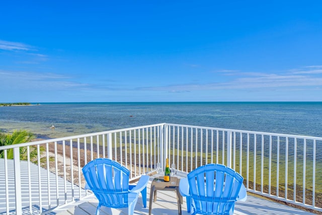 balcony featuring a beach view and a water view