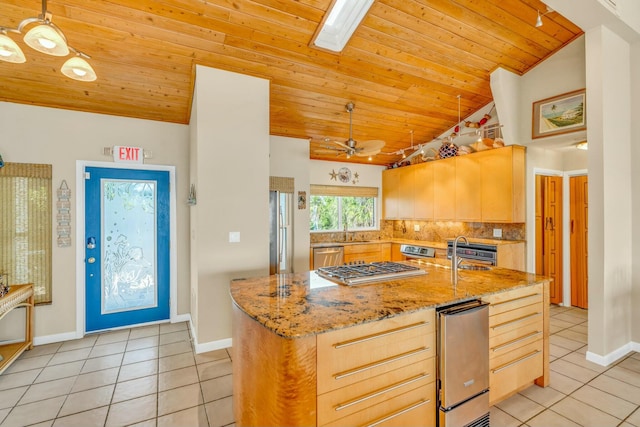 kitchen with pendant lighting, light brown cabinetry, light tile patterned floors, and stainless steel appliances