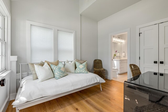 1114 Grinnell St, Key West, FL 33040 - bedroom featuring light wood finished floors, connected bathroom, and multiple windows