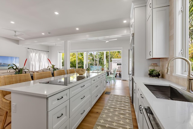 1114 Grinnell St, Key West, FL 33040 - kitchen with black electric cooktop, plenty of natural light, a kitchen bar, recessed lighting, and light wood finished floors