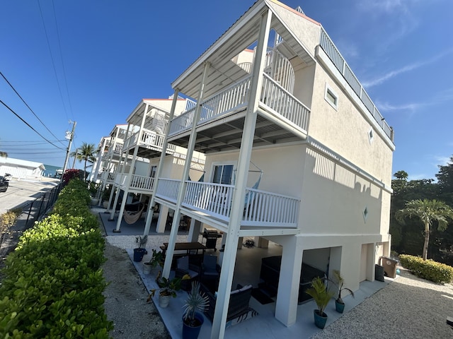 rear view of house featuring stucco siding