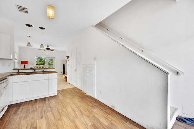 kitchen with decorative light fixtures, sink, light hardwood / wood-style flooring, and white cabinets