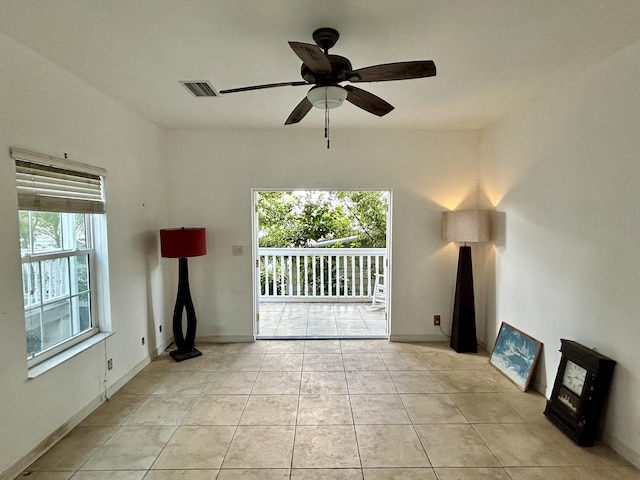 unfurnished living room featuring a healthy amount of sunlight, light tile patterned floors, and ceiling fan