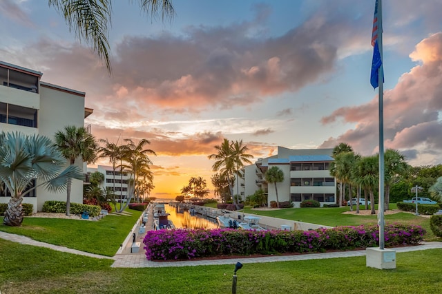 view of home's community with a water view and a lawn