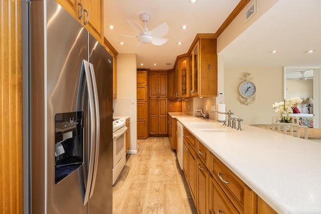 kitchen featuring ceiling fan, white appliances, sink, and light hardwood / wood-style flooring