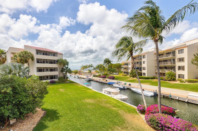 surrounding community featuring a water view and a lawn