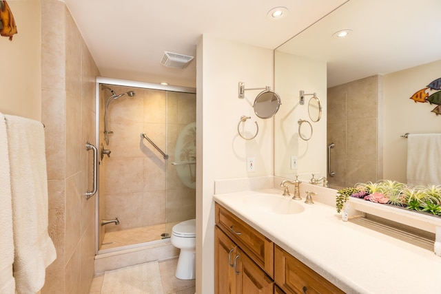 bathroom with tile patterned flooring, vanity, an enclosed shower, and toilet