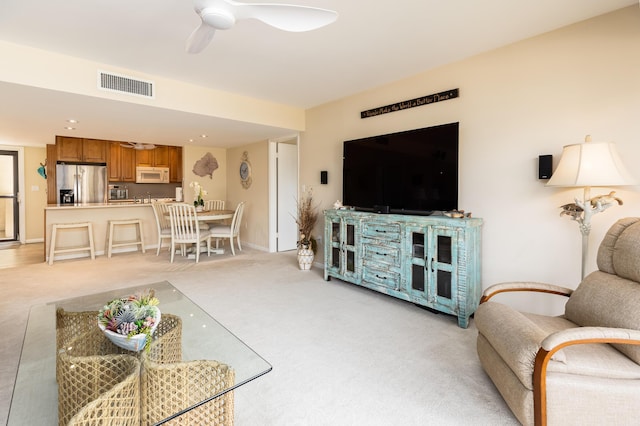 carpeted living room with ceiling fan