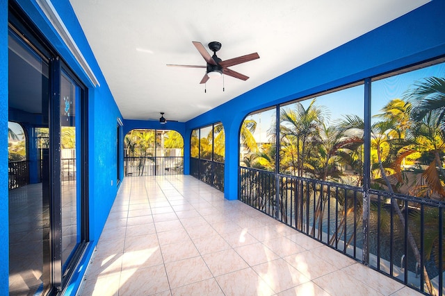 unfurnished sunroom with ceiling fan