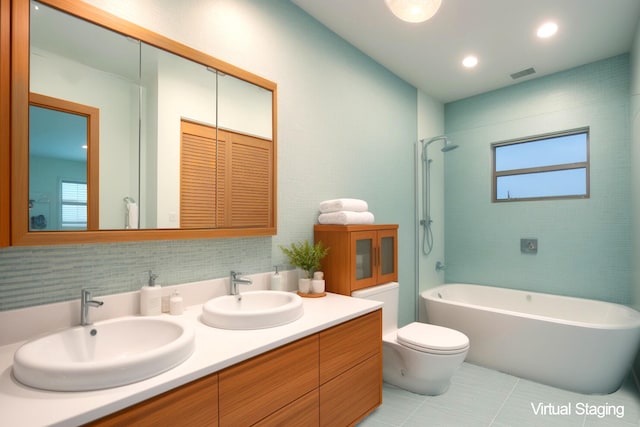 bathroom with tile patterned floors, vanity, toilet, and a wealth of natural light