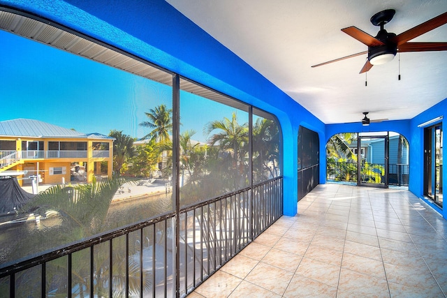 unfurnished sunroom featuring ceiling fan