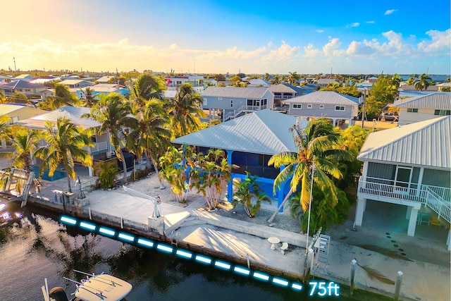 aerial view at dusk featuring a water view