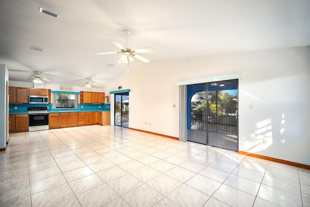 interior space featuring lofted ceiling, light tile patterned floors, range with electric stovetop, and ceiling fan