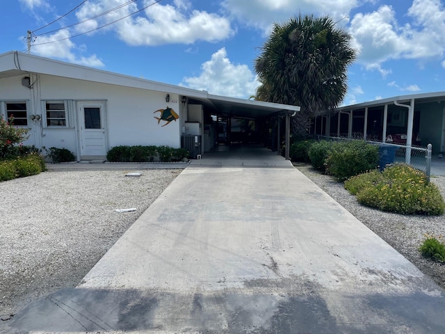 460 11th St, Key Colony, FL 33051 - view of front facade featuring driveway, stucco siding, and a carport