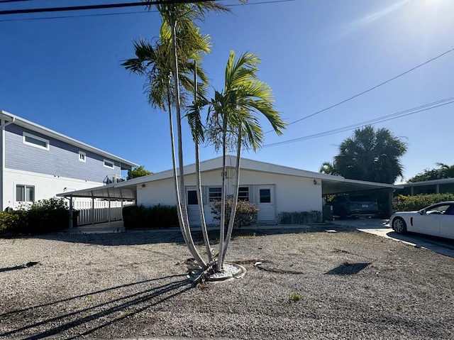 view of front facade with a carport and stucco siding