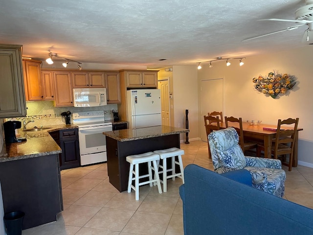 kitchen with tasteful backsplash, brown cabinetry, a kitchen island, a sink, and white appliances