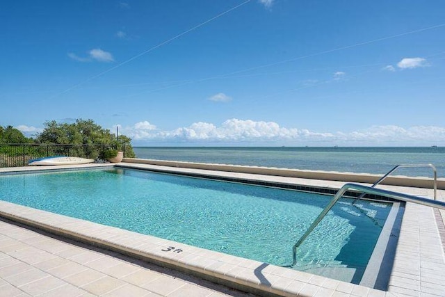 pool featuring a water view and fence