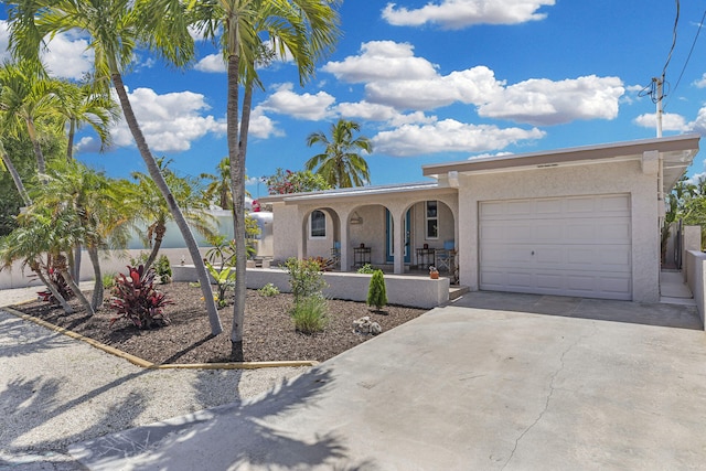 102 Sands Ln, Layton, FL 33001 - view of front facade featuring a porch, driveway, stucco siding, and an attached garage