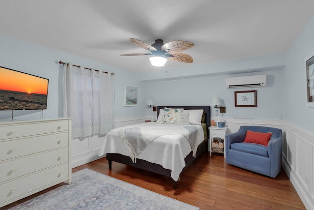 102 Sands Ln, Layton, FL 33001 - bedroom featuring a wall mounted air conditioner, wood finished floors, a wainscoted wall, and a ceiling fan