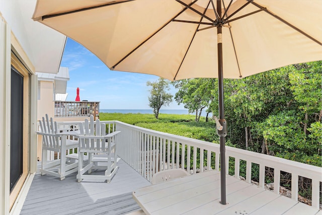 deck featuring outdoor dining space and a water view