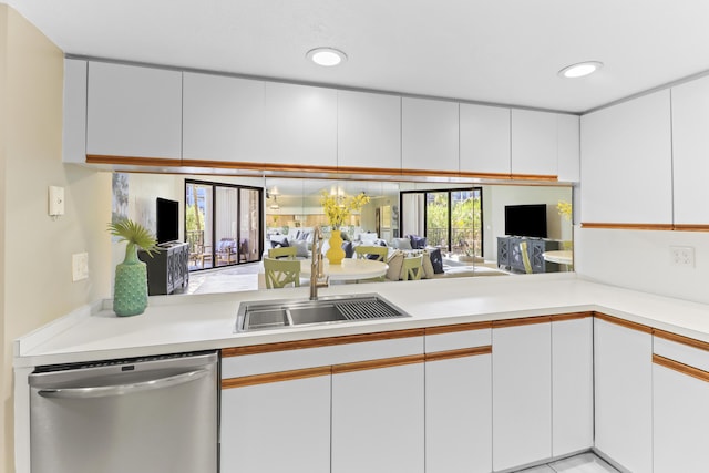 kitchen with white cabinetry, dishwasher, sink, and kitchen peninsula