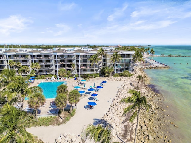 birds eye view of property with a water view and a beach view