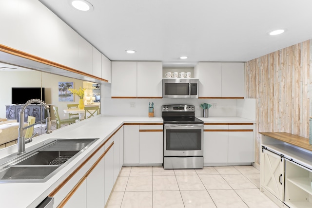 kitchen with stainless steel appliances, sink, and white cabinets