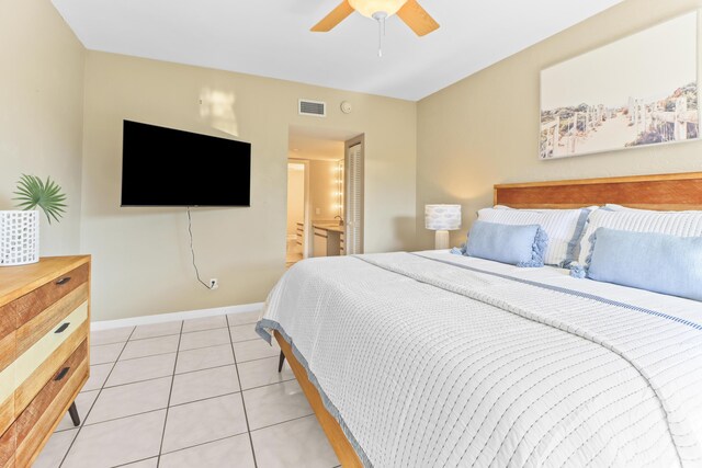 tiled bedroom with connected bathroom and ceiling fan