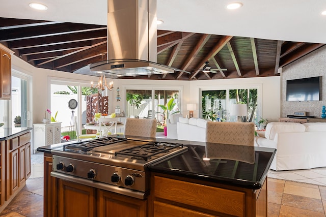 kitchen featuring a healthy amount of sunlight, stainless steel gas cooktop, beamed ceiling, and island exhaust hood