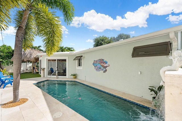 view of swimming pool with pool water feature and a patio