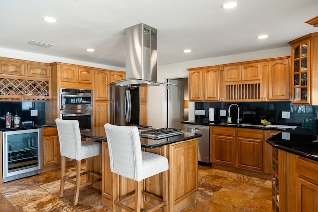 kitchen featuring appliances with stainless steel finishes, a kitchen breakfast bar, island range hood, a kitchen island, and beverage cooler