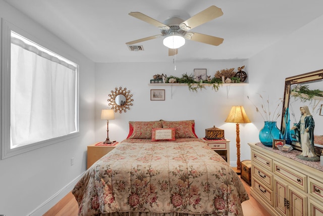 bedroom with visible vents, light wood-style flooring, ceiling fan, and baseboards