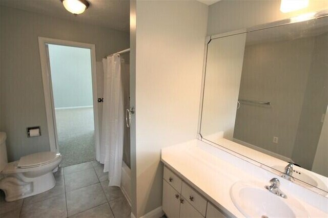 full bathroom with tile patterned flooring, vanity, shower / bath combo, and toilet