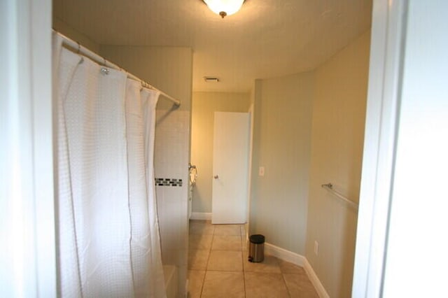 bathroom with tile patterned floors and curtained shower