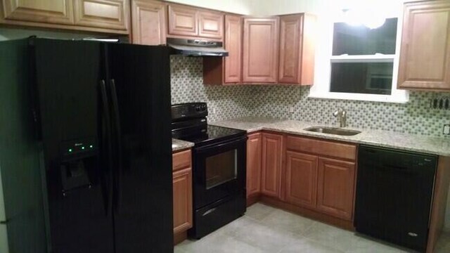 kitchen featuring backsplash, sink, and black appliances