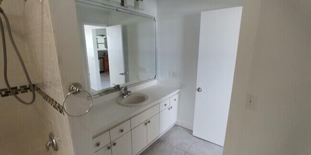 bathroom featuring tile patterned flooring, vanity, and walk in shower