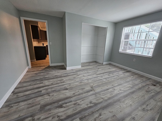 unfurnished bedroom with hardwood / wood-style floors and a closet