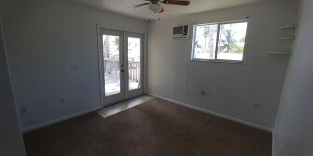 carpeted empty room with a wealth of natural light, french doors, and ceiling fan