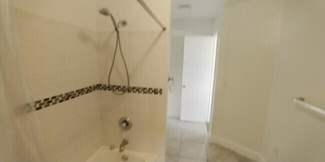 bathroom with tile patterned flooring and tiled shower / bath