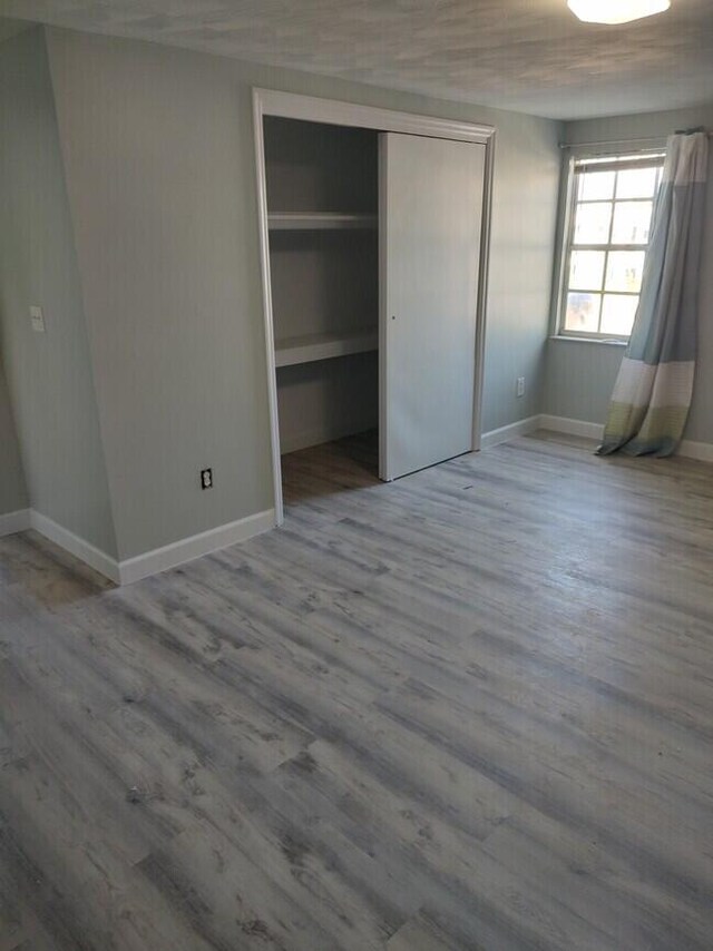 unfurnished bedroom with wood-type flooring and a closet