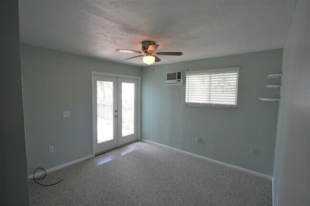 unfurnished room featuring french doors, a healthy amount of sunlight, carpet floors, and a wall unit AC