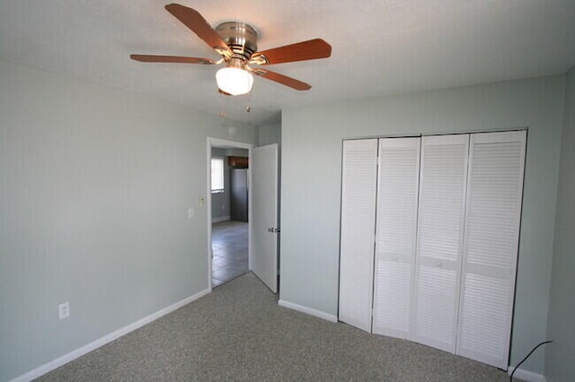 unfurnished bedroom with ceiling fan, a closet, and carpet