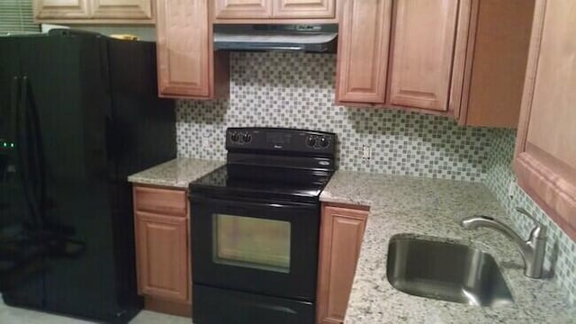 kitchen featuring backsplash, sink, light stone counters, and black appliances