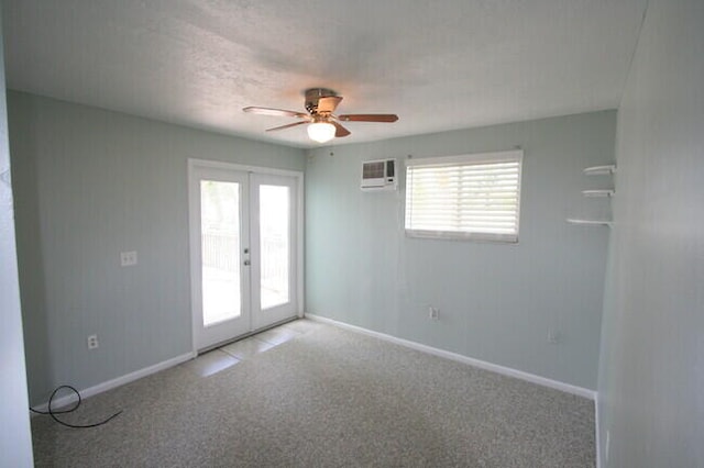 spare room featuring ceiling fan, french doors, a wall mounted AC, and carpet