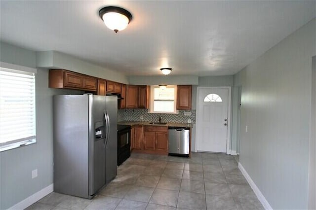 kitchen featuring light tile patterned floors, sink, backsplash, stainless steel appliances, and ventilation hood