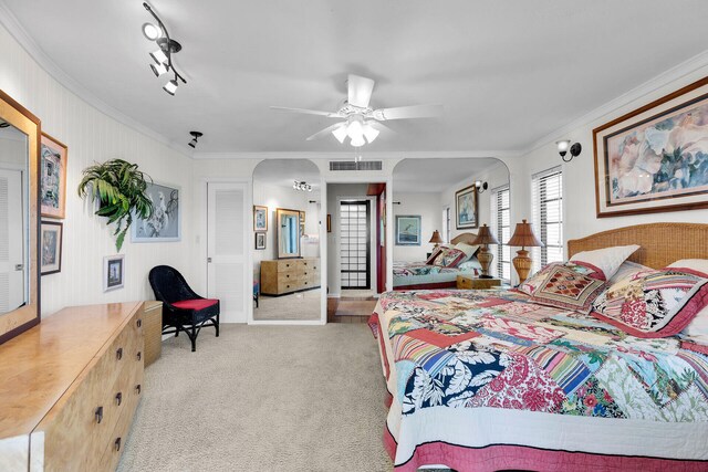 bedroom featuring crown molding, light colored carpet, and ceiling fan