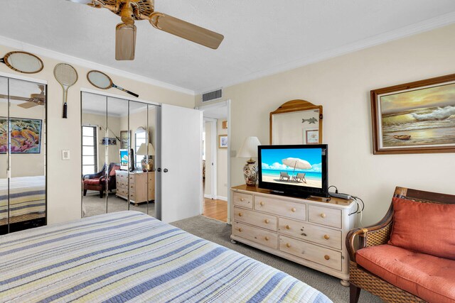 carpeted bedroom featuring ornamental molding and ceiling fan