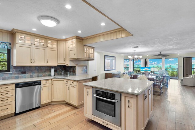 kitchen with sink, tasteful backsplash, a center island, appliances with stainless steel finishes, and pendant lighting